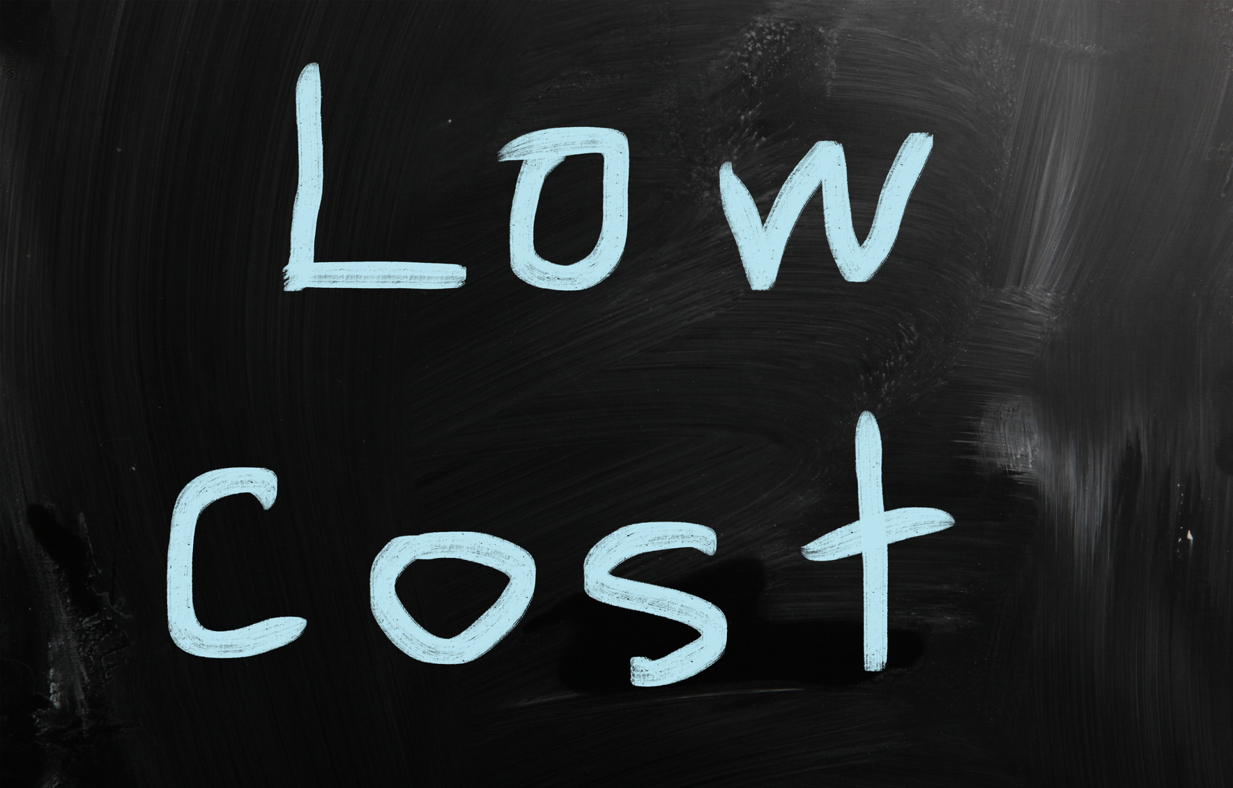 "Low cost" handwritten with white chalk on a blackboard